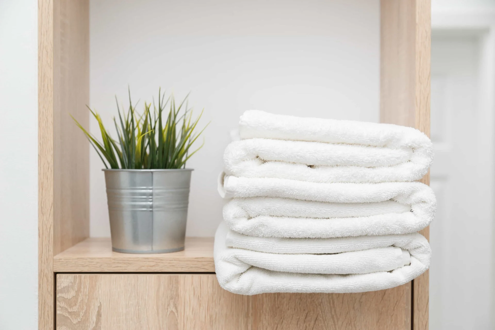 stack-of-clean-towels-on-shelf-with-greens-in-buck-46SYGC8-min